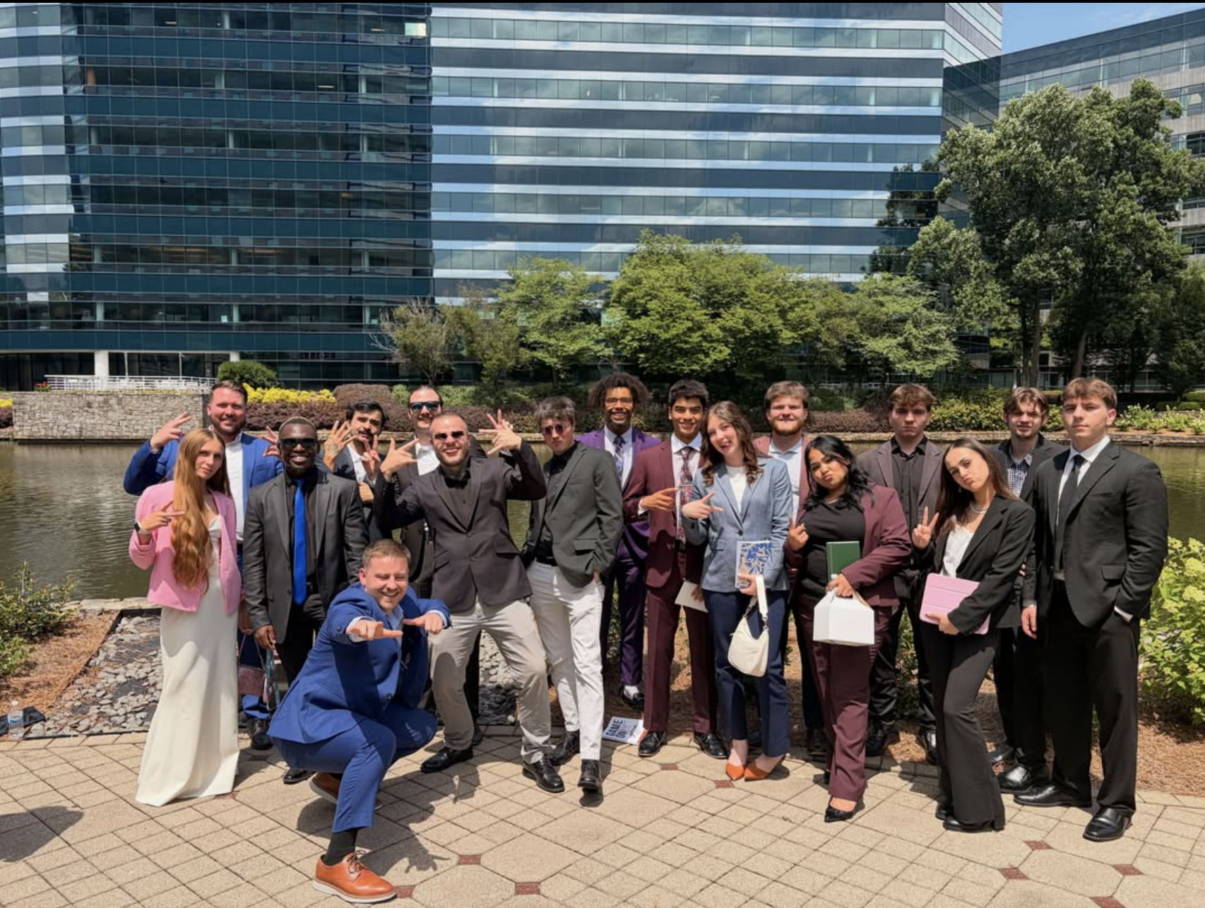 A large group of Revamped Marketing team members posing together outside a modern office building
